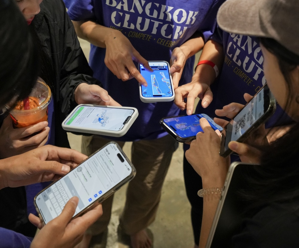 A group of climbers gathered around their phones using the Griptonite app