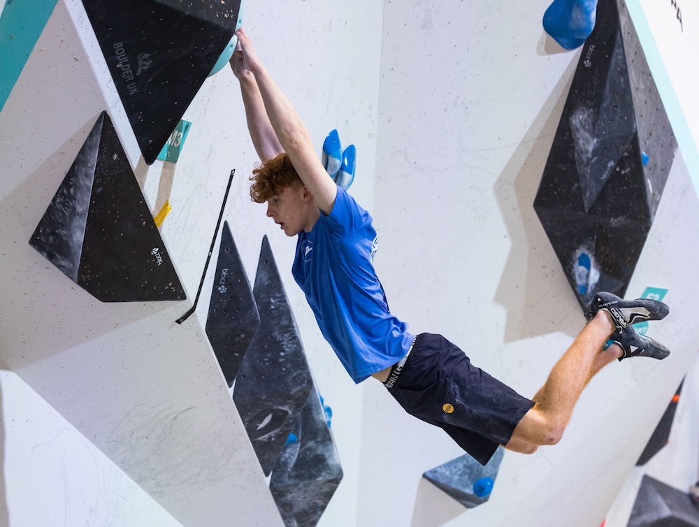 Climber making a dynamic move on a steep bouldering wall