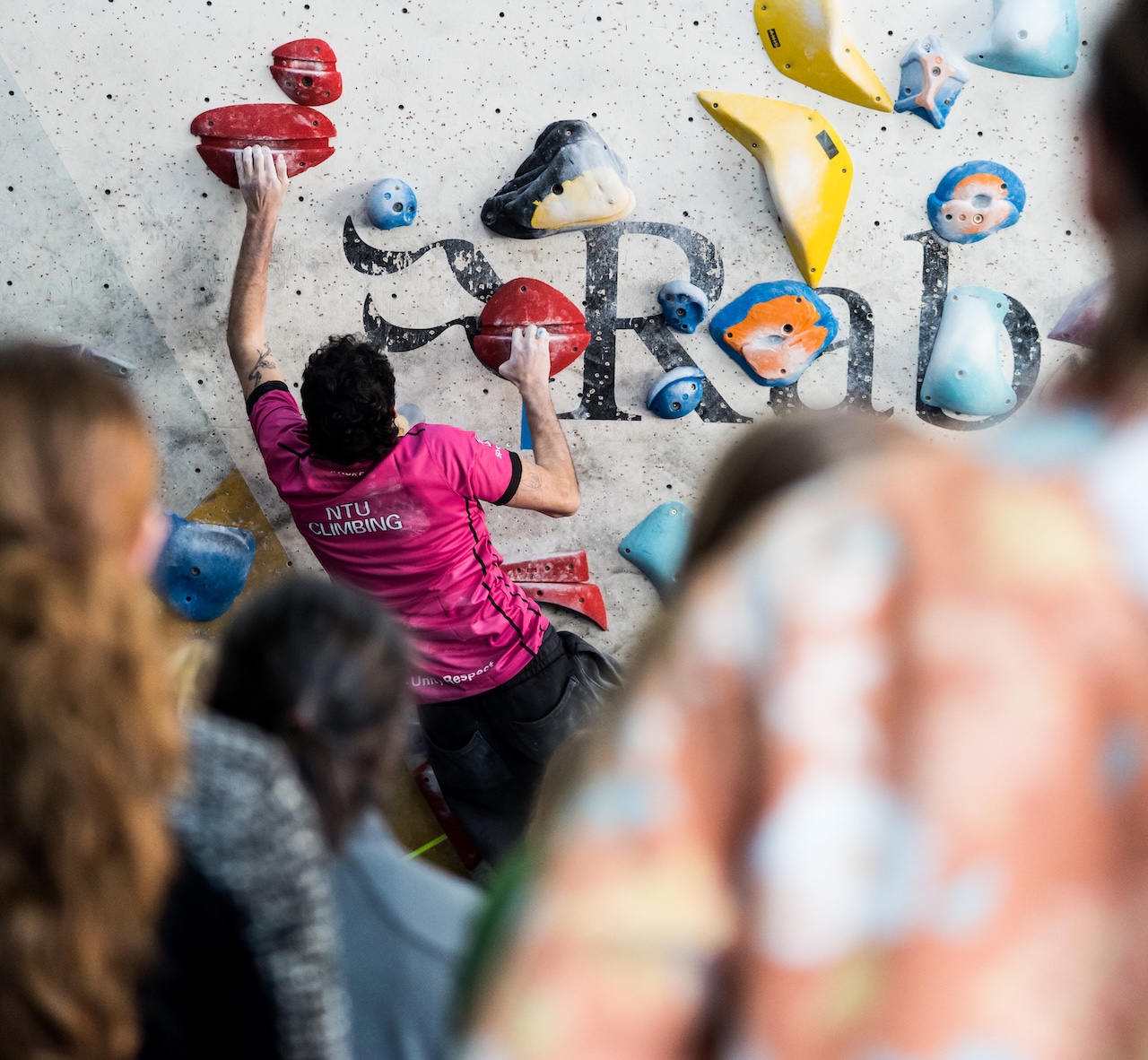Climber on a bouldering wall at a series event