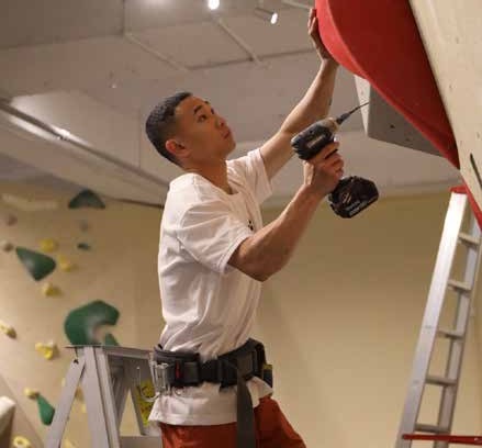 Route setter working on a climbing wall