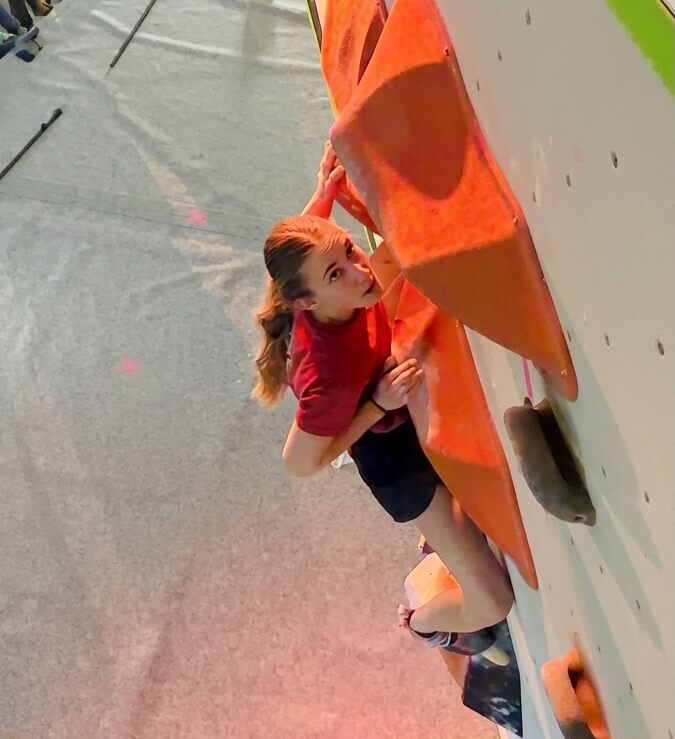 A climber maintaining balance on an indoor climbing wall