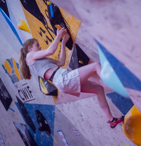 A climber on an indoor bouldering wall